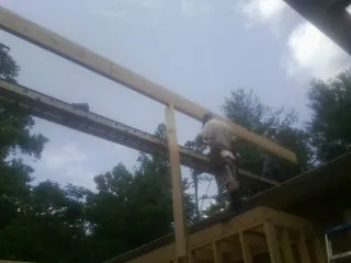 Carpenter setting a ridge beam over a new addition frame — Ice Dam Removal by Roofing Brothers in Savanna