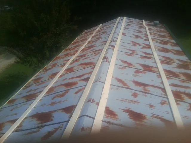 Rusted metal roof panels with new wood purlins before replacement — Storm Damage Roof Repair in Savanna by Roofing Brothers