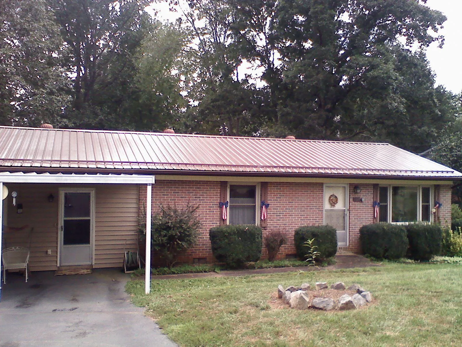 Bronze metal roof and carport on a brick ranch home — Roof Repair work by our crew in Savanna