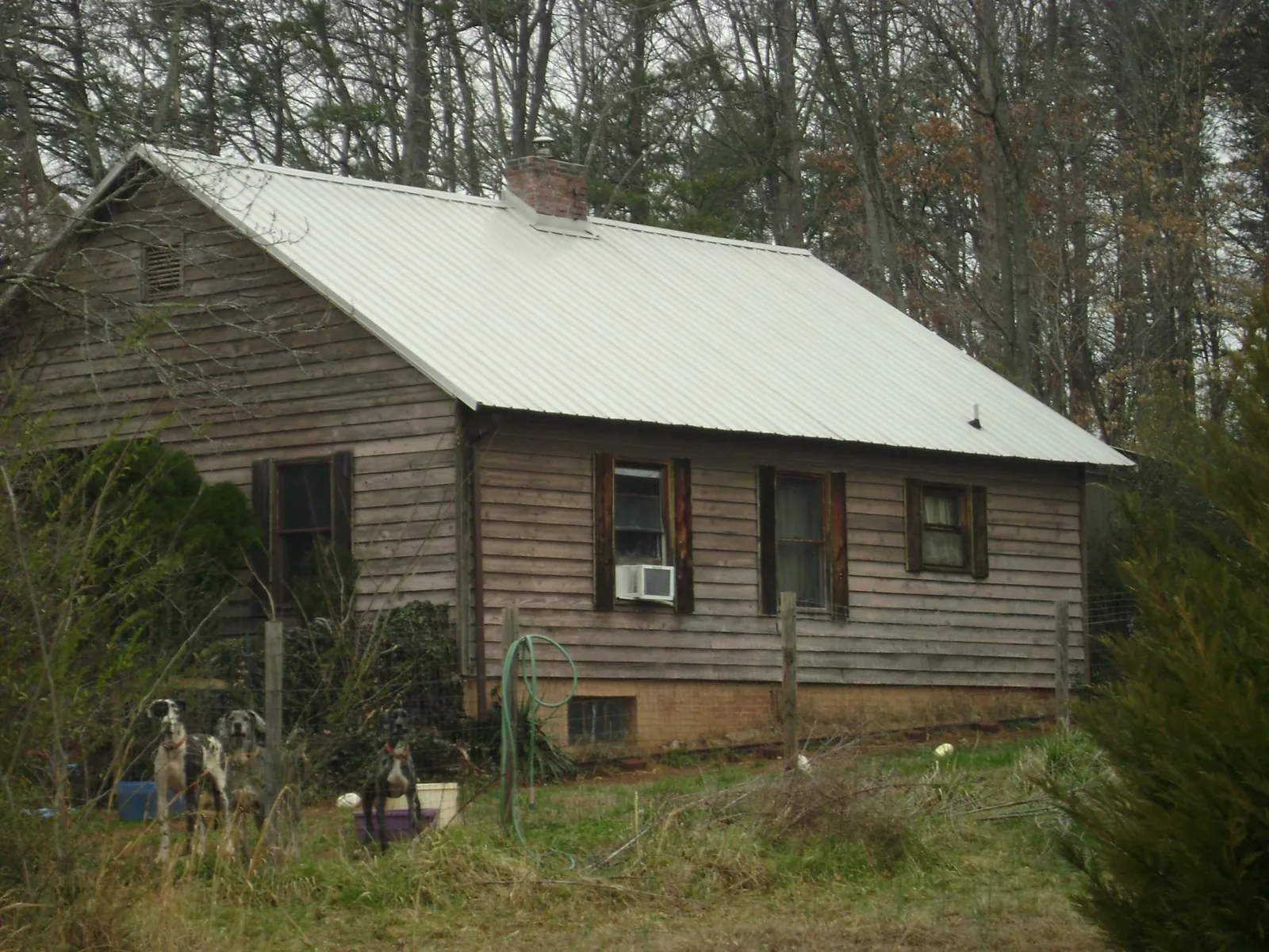 White metal roof on an old wood sided farmhouse, from a Metal Roof Installation job in Savanna